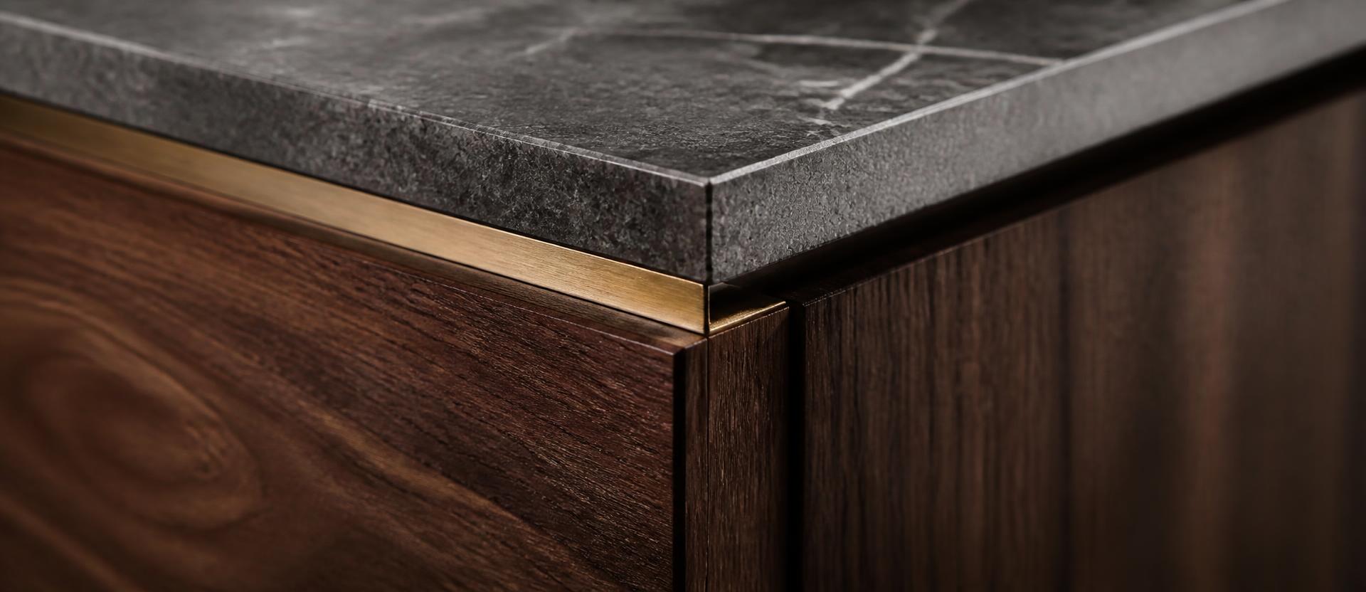 Detail: Natursteinabdeckung trifft auf geölte Nussbaumfront